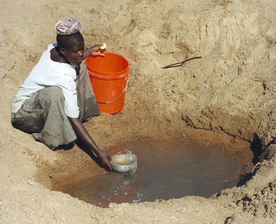  Mwamanongu Village water source, Tanzania. "In Meatu district, Shinyanga region, Tanzania, water most often comes from open holes dug in the sand of dry riverbeds, and it is invariably contaminated." Photo: Bob Metcalf/Wikimedia Commons